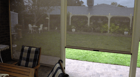 Outdoor area with mesh zip screen blinds providing partial shade and visibility to the garden and veranda in the backyard.